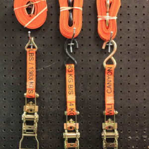 Product Photo of Ratchet Straps. They are displayed on a product wall. The ratchet straps each have different hook types. The straps are orange.