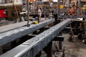 This photo displayed Canyon Rigging's custom rigging workshop. In the workshop there is a custom spreader bar that is being prepared for the customer. The spreader bar is welded and waiting for holes to make it into an adjustable spreader beam.